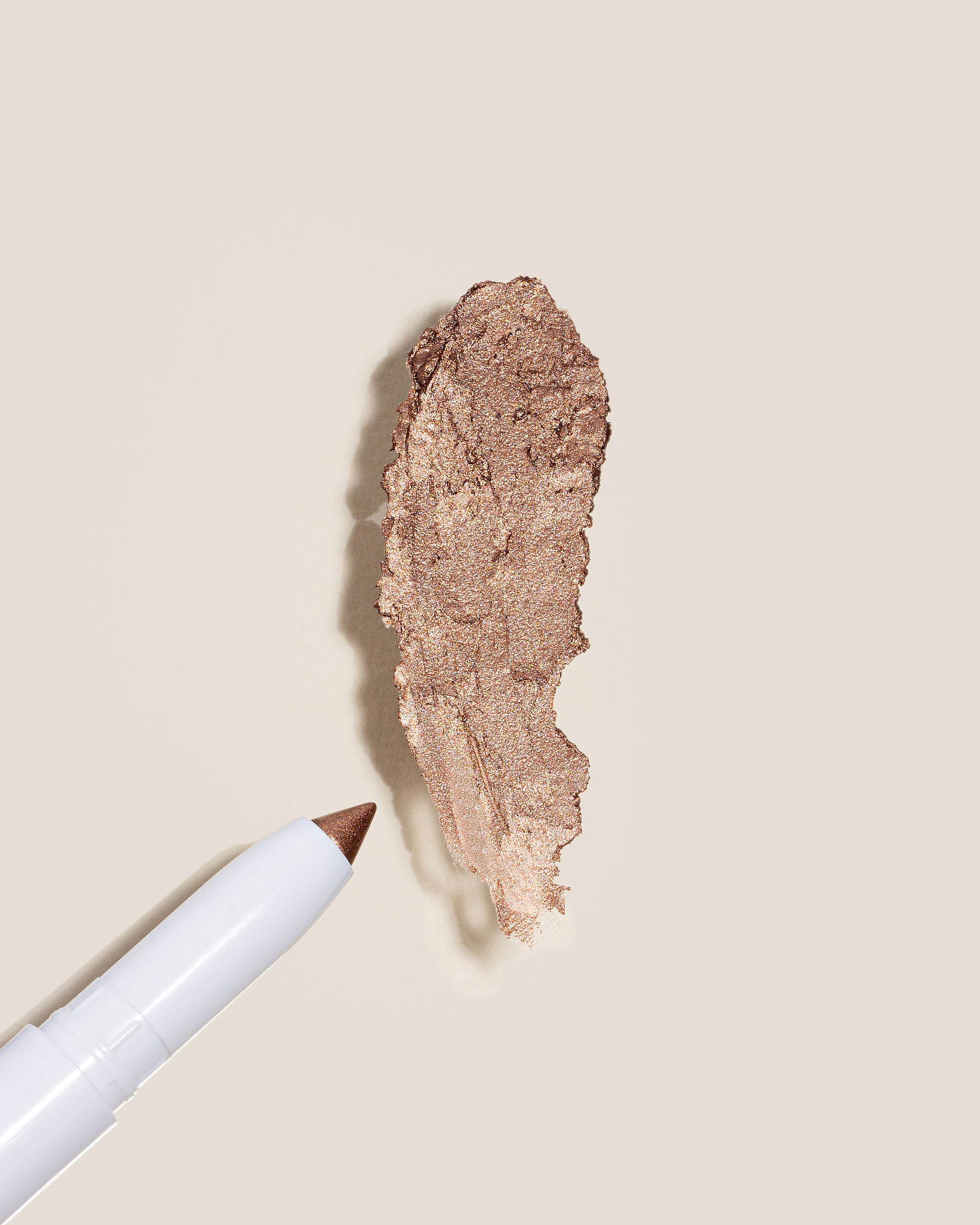 Swatch of Rose Colored Glasses, a rose gold shimmer of the cream eye shadow stick for a natural shimmer that highlights eyes